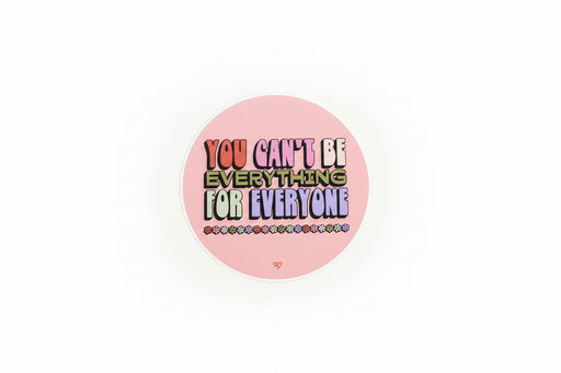 Round sticker with motivational text 'You can't be everything for everyone' on a pink background